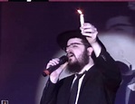 Benny Friedman holding a candle, singing don’t let the light go out ...