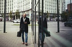Full length of businessman using mobile phone while walking on sidewalk ...