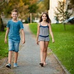 Young teenage boy and girl walk in park in the city Stock Photo by ...