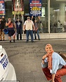Smiling woman in hijab flashing peace sign in front of anti-Muslim ...