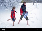 portrait of two young boys walking barefoot in the snow Stock Photo - Alamy