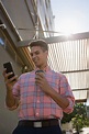 Young Man Using Mobile Phone while Walking by Building Stock Image ...
