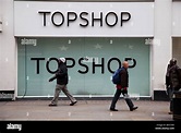 People walk past the shop front to high street fashion chain store ...