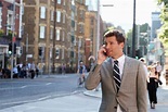 Businessman Talking On Mobile Phone Walking Along City Street - Stock ...
