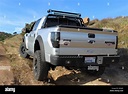 Silver and black customized Ford F150 Raptor SVT climbing a hill on ...