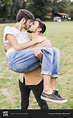 Kissing young gay couple in a park stock photo - OFFSET