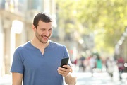 Happy Man Walking Using Mobile Phone in the Street Stock Image - Image ...