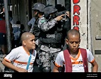 Children walk by National Security Force officers during an operation ...