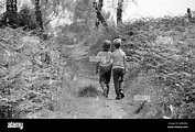 two boys walking along a woodland path Stock Photo - Alamy