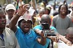 An Anglo platinum mine worker waves money in the air during a strike ...
