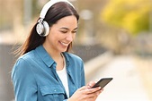 Happy Woman Listens To Music or is Watching Media on Phone Stock Image ...