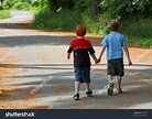 Two Young Boys Holding Hands Walking Down The Road Stock Photo 943249 ...